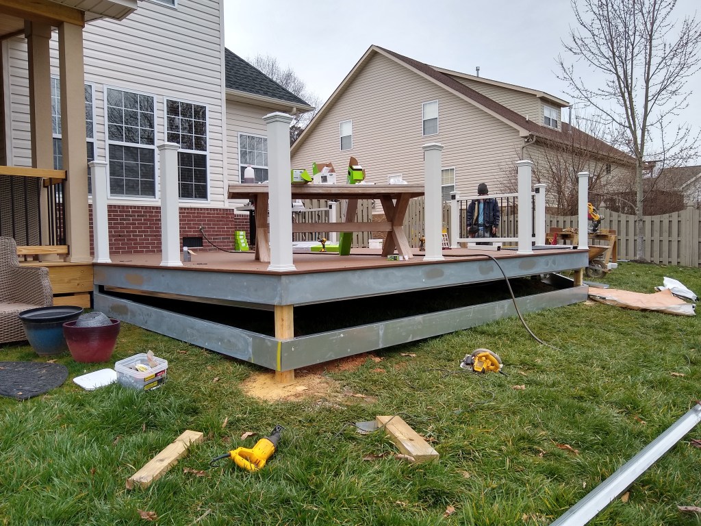 Deck builders installing handrail post